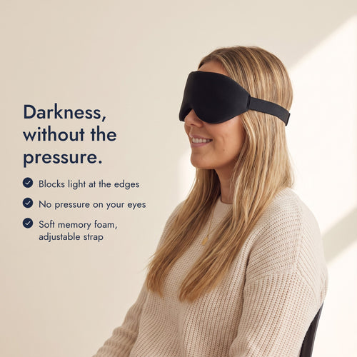 Woman wearing the Northdusk mask in profile. Darkness, without the pressure: blocks light at the edges, no pressure on your eyes, soft memory foam, adjustable strap.