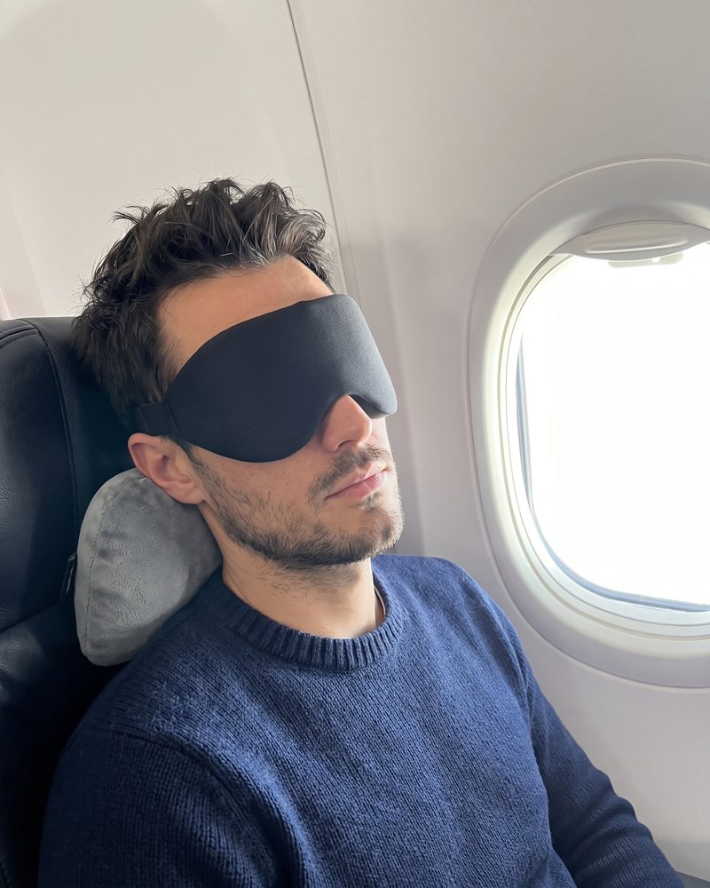 Asleep in the mask in a plane window seat